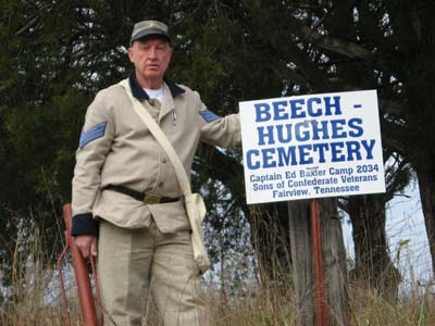 Photo of Camp Cmd. Billy Adcock standing beside the Beech-Hughes Cemetery sign.