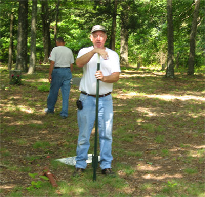 Camp 2034 member Billy Adcock prepares to install the cemetery sign.